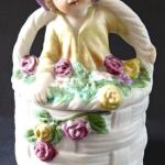 Die Dose, Korb, mit Rosen und Statuette Die Dose, Korb, mit Rosen und Statuette