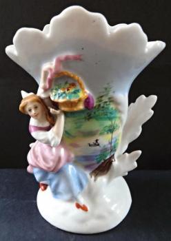 Vase mit einer Mädchenfigur und einem Korb Vase mit einer Mädchenfigur und einem Korb