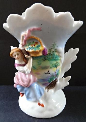 Vase mit einer Mädchenfigur und einem Korb Vase mit einer Mädchenfigur und einem Korb